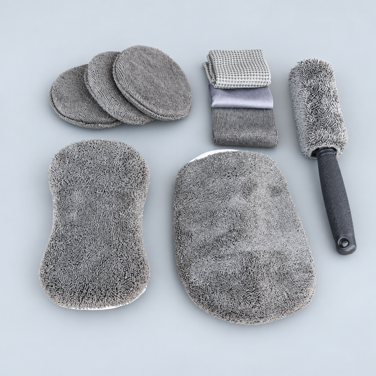 Nine grey car cleaning pieces with wheel brush, sponge, mitt, cloths and pads