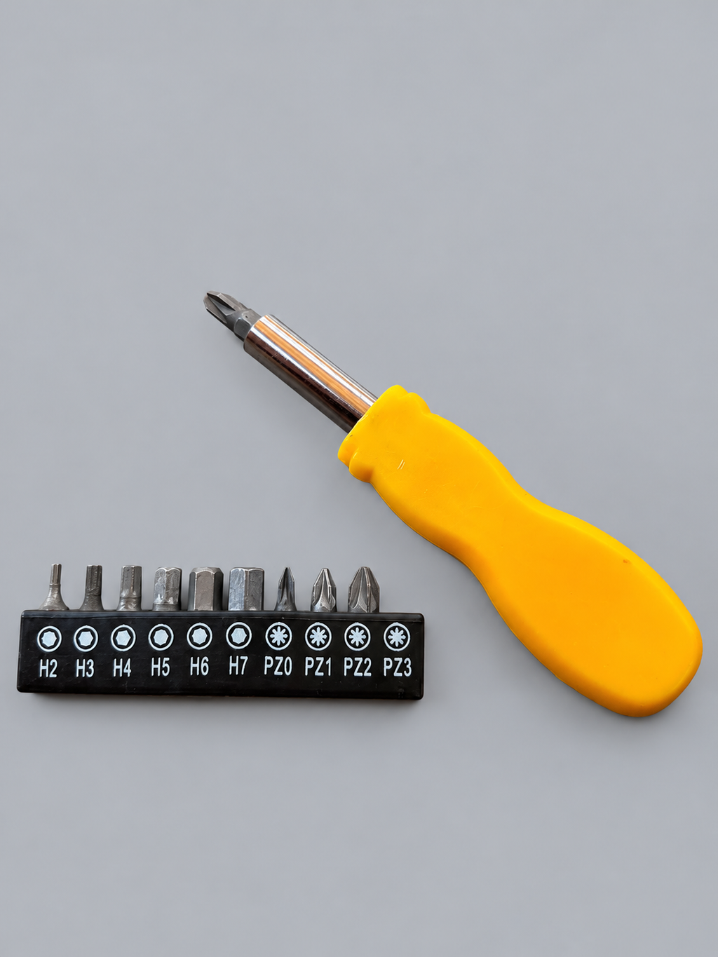 Yellow screwdriver handle fitted with one bit and remaining nine in holder